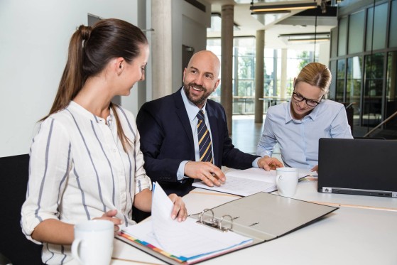 Three-business-people-sitting-at-a-desk