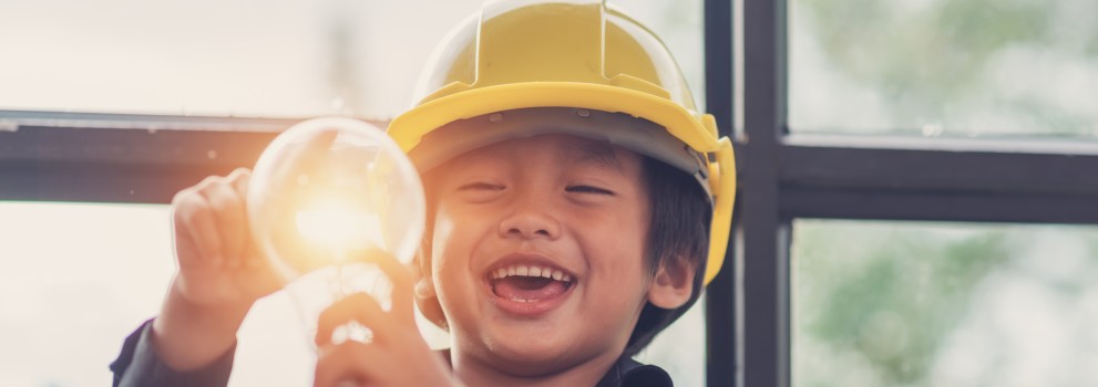 Enfant souriant qui tient une ampoule