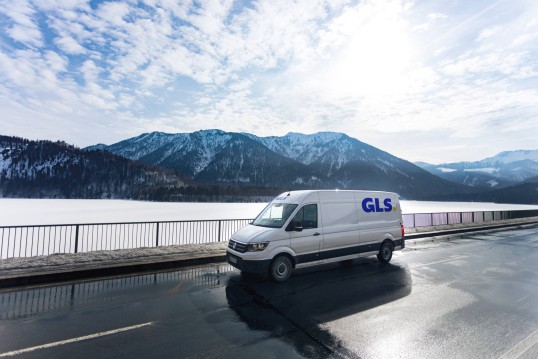 GLS driver walking through the snow to deliver a parcel