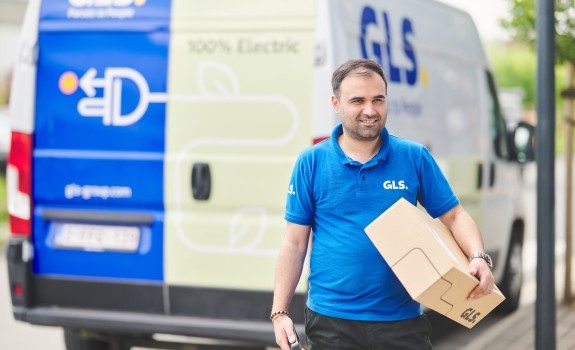 Bezorger die een pakket vasthoudt voor zijn e-van
