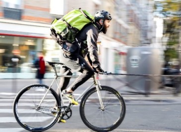 Cyclist delivery person with a delivery bag, illustrating a sustainable last-mile delivery solution in Paris.