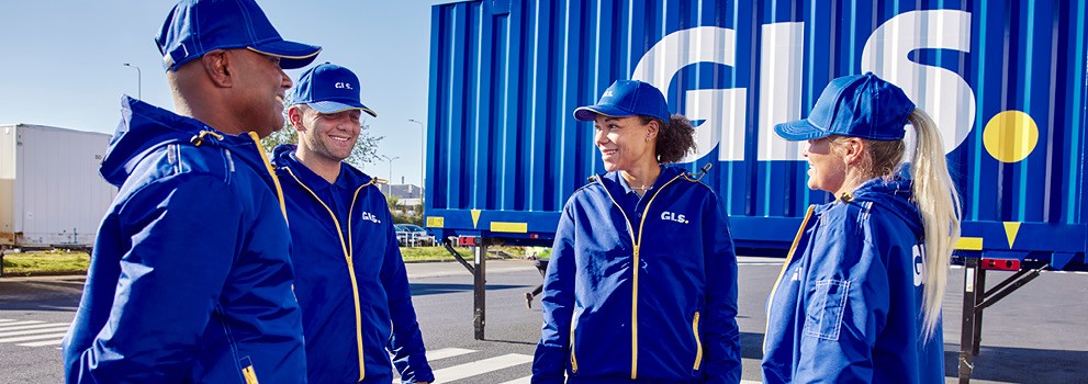 Employés GLS en tenue professionnelle sur site logistique, devant un conteneur de transport, illustrant les services de livraison de colis et la logistique du dernier kilomètre.