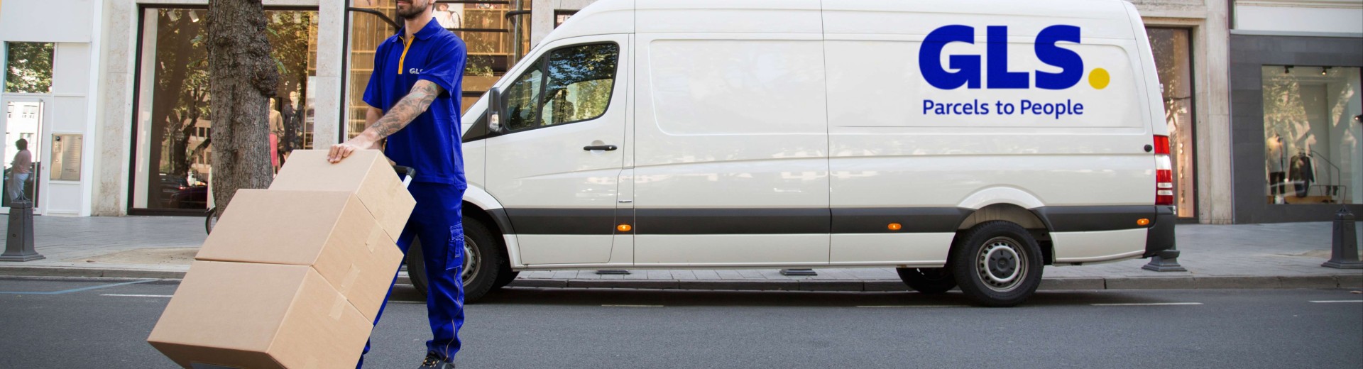Lieferant trägt Pakete vor seinem Lieferwagen