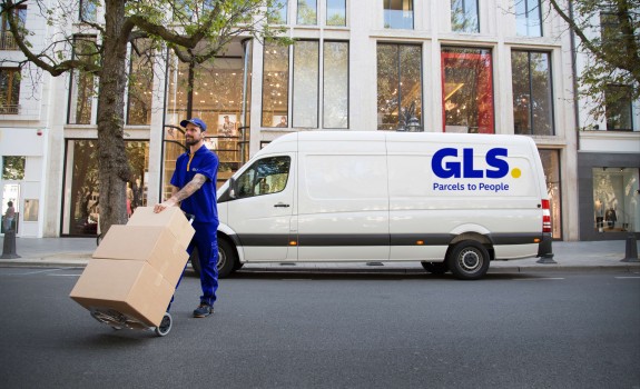Lieferant trägt Pakete vor seinem Lieferwagen