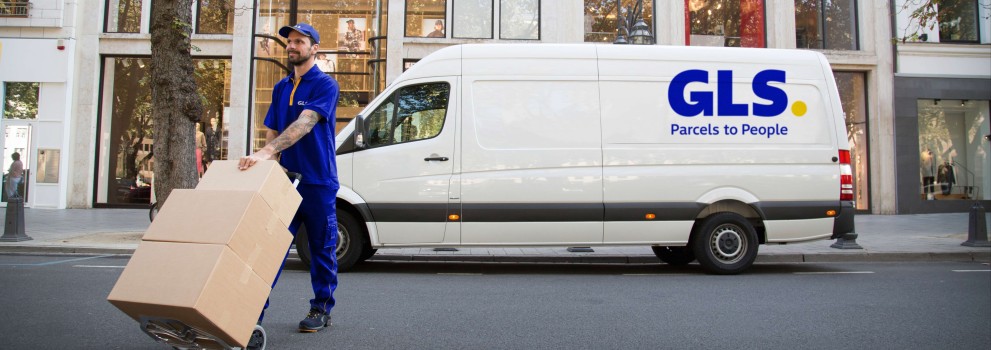 Lieferant trägt Pakete vor seinem Lieferwagen