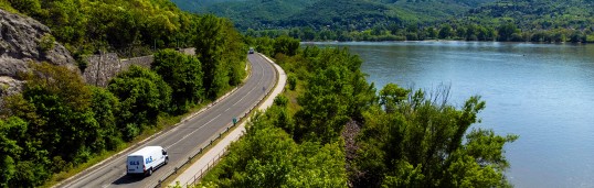 Tovornjak se vozi po cesti ob naravi