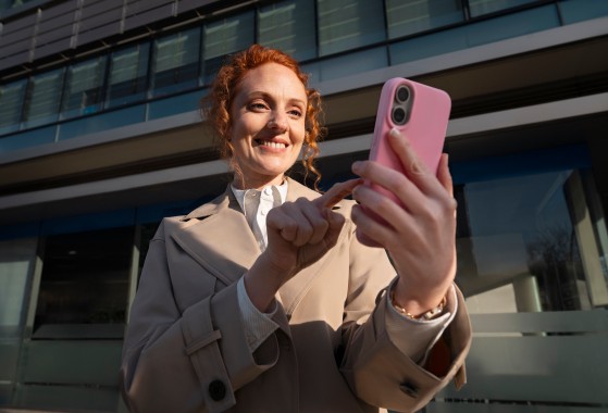 Ženska na ulici gleda v telefon