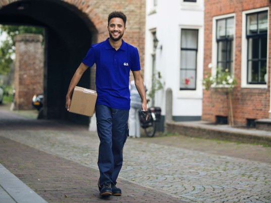 GLS courier with parcel on the street